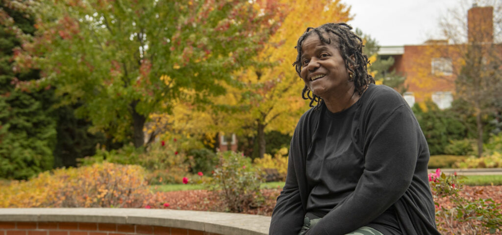 Audrey Geddis sitting outside on a brick bench