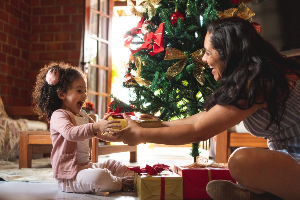 Mom handing present to young girl